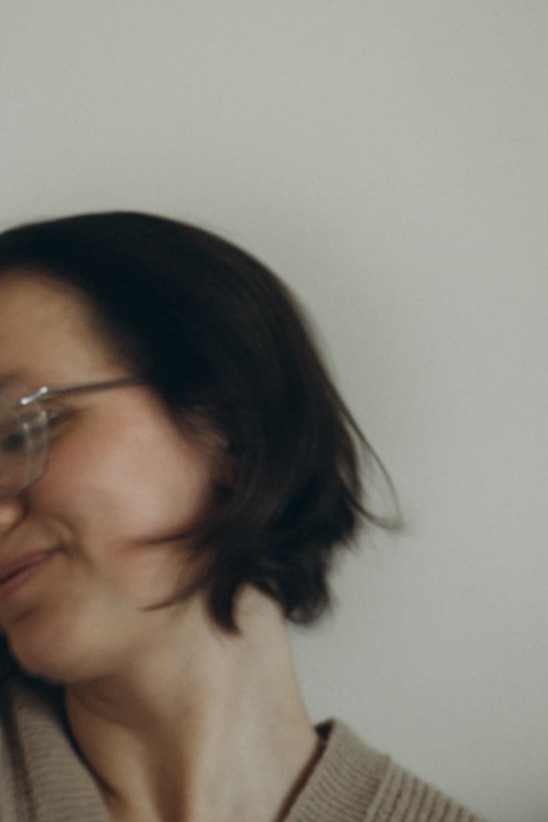 Self-portrait in glasses, smiling over the shoulder in motion blur